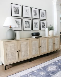 a living room with pictures on the wall and an area rug in front of it