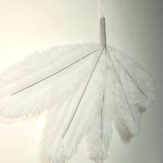 a white feather umbrella hanging on a wall