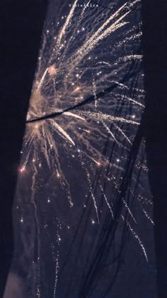 fireworks are lit up in the night sky above an umbrella with string attached to it