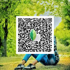 a person sitting on the ground in front of trees with a qr code over their face