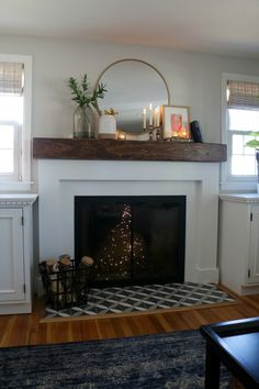 a living room with a fire place and christmas tree on the mantel above it