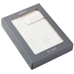 an open box with a white greeting card inside