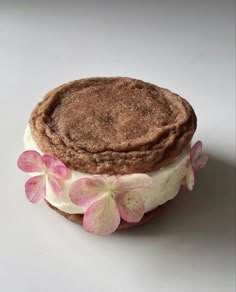 a cookie sandwich with white frosting and pink flowers