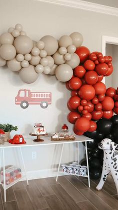 a party with balloons and firetrucks on the wall