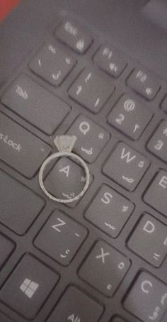 a ring sitting on top of a computer keyboard with the word love written on it