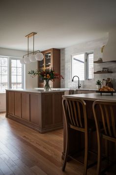 a kitchen with wooden floors and white walls