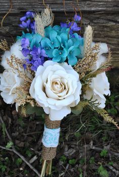 a bridal bouquet with blue and white flowers on the side of a wooden bench