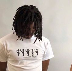 a man with dreadlocks wearing a t - shirt that has the image of people on it