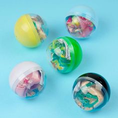 four plastic containers filled with different types of toys on top of a blue surface,