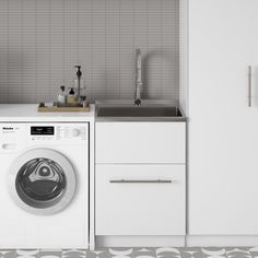 a washer and dryer in a small room with tile flooring on the walls