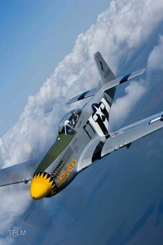 a fighter jet flying through the air with clouds in the background