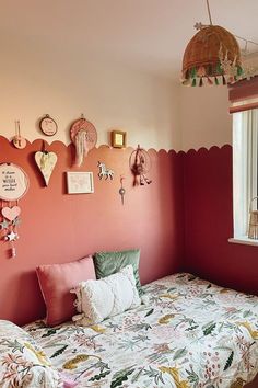 a bedroom with pink walls and colorful decorations on the wall, including a twin bed