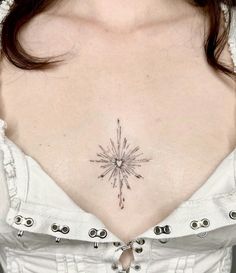 a woman's chest with a small star tattoo on her left side ribcage