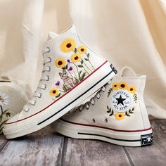 Custom Embroidered Converse High Tops 1970s, Sunflower Embroidered Shoes Custom, Cat and Gardens Sunflower Embroidered Converse, Gift for Women 💚 Immerse yourself in the intricate craftsmanship as we lovingly hand embroider rustic flowers onto your chosen Converse pair 💚 🌿 The listed price encompasses both the Converse Shoes and the showcased Embroidery Designs. 1. MANUFACTURING PROCEDURE 🌿 Upon receiving your order, we initiate the shoe preparation process. If your chosen shoes are readily Embroidered Converse High Tops, Converse Chuck 70s, Embroidered Sneakers, Embroidered Converse, Embroidered Shoes, Shoes Photo, Shoes Custom, Rustic Flowers, Sneakers Athletic