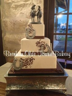 a three tiered wedding cake with cowboy decorations