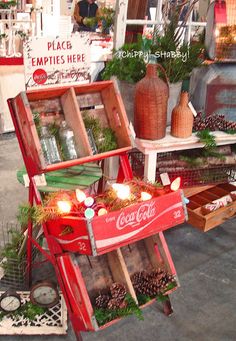 an old coca - cola cart is decorated with pine cones and greenery