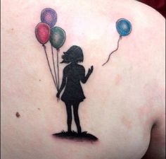 a girl with balloons tattoo on her back shoulder