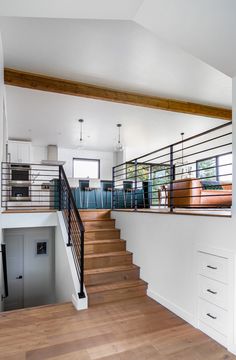 an open floor plan with stairs leading up to the kitchen and living room area in this modern home