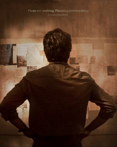 a man standing in front of a wall with pictures on it and the words plan are nothing planning is everything