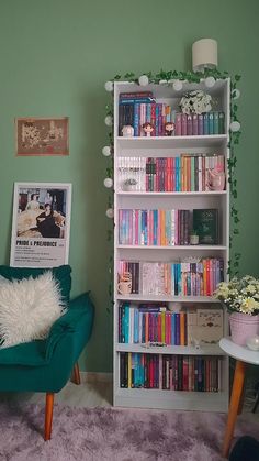 a green chair in front of a bookshelf filled with lots of books and flowers