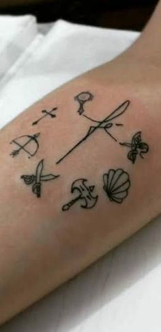 a person with a tattoo on their arm that has flowers and scissors drawn on it