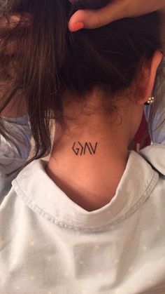 a woman with a tattoo on her neck that says vkg in the middle