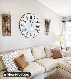 a living room filled with furniture and a large clock mounted to the wall above it