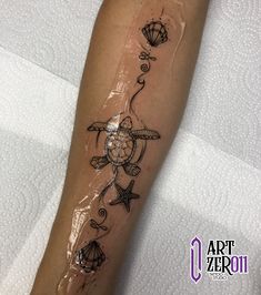 a tattoo on the leg of a woman with sea animals and seashells around her