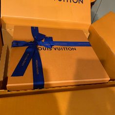 two boxes with blue ribbons are stacked on top of each other in the same box