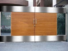 an entrance to a building that has wooden doors and metal trimmings on it