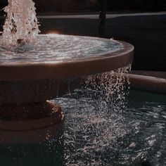 a fountain with water spouting out of it's sides at night time