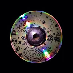 an upside down cd with many drawings on the disc and lights in front of it