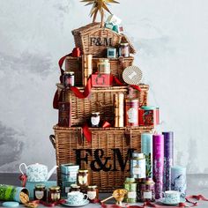 a christmas tree made out of wicker and wrapped in red ribbon with gifts around it