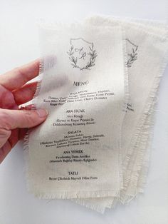 a person holding up a menu on top of a piece of cloth