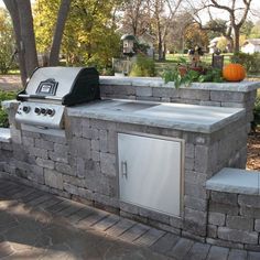 an outdoor kitchen with grill and sink