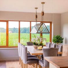 a dining room table with chairs and a chandelier hanging from it's ceiling