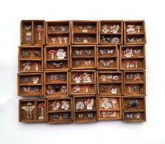 several wooden boxes filled with small figurines on top of each other in different shapes and sizes