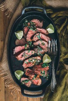 a pan filled with steaks on top of a wooden table