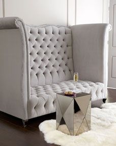 a white couch sitting on top of a hard wood floor next to a glass table