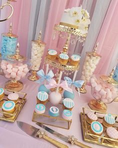 a table topped with cupcakes, candy and cake pops on top of gold trays