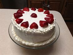 a cake with white frosting and strawberries on top