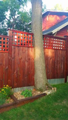 a wooden fence next to a tree in a yard