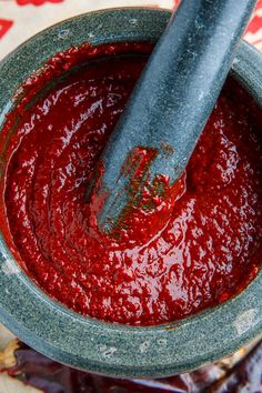 a bowl filled with ketchup on top of a table