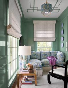 a living room filled with furniture and green walls