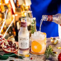 a bottle of alcohol being poured into a glass next to a pomegranate