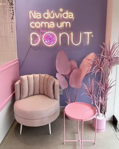 a pink chair and table in front of a sign that says natdividda, comma um donut