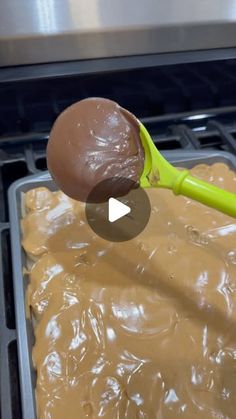 a spoon with some kind of food on top of it in front of an oven