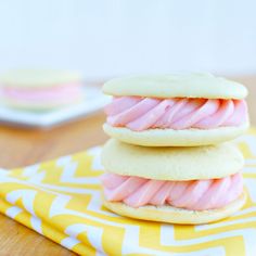 three cookies with pink icing stacked on top of each other