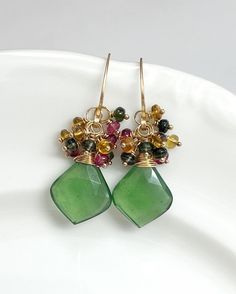 This beautiful pair features AAA Faceted Leaf-Shaped Serpentine briolettes, crowned with clusters of the most magnificent Tourmalines. Everything has been meticulously hand wrapped with 14k Gold Filled wire. Earring wires are hand forged by me, as always!  Length is approximately 1 1/2 inches. 🌿Jewelry arrives beautifully packaged in a sturdy box, wrapped with ribbon or twine. The box is perfect for gift giving or safe keeping. 🌿Please double check your name and address during checkout. Thank Handmade Tourmaline Green Earrings, Handmade Green Tourmaline Earrings, Green Tourmaline Earrings For Gift, Wire Earring, Diy Earring, Tourmaline Earrings, Earring Wires, Earring Ideas, Writing Gifts