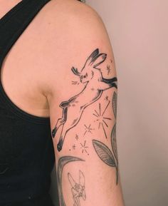 a woman with a tattoo on her arm has an image of a rabbit flying through the air